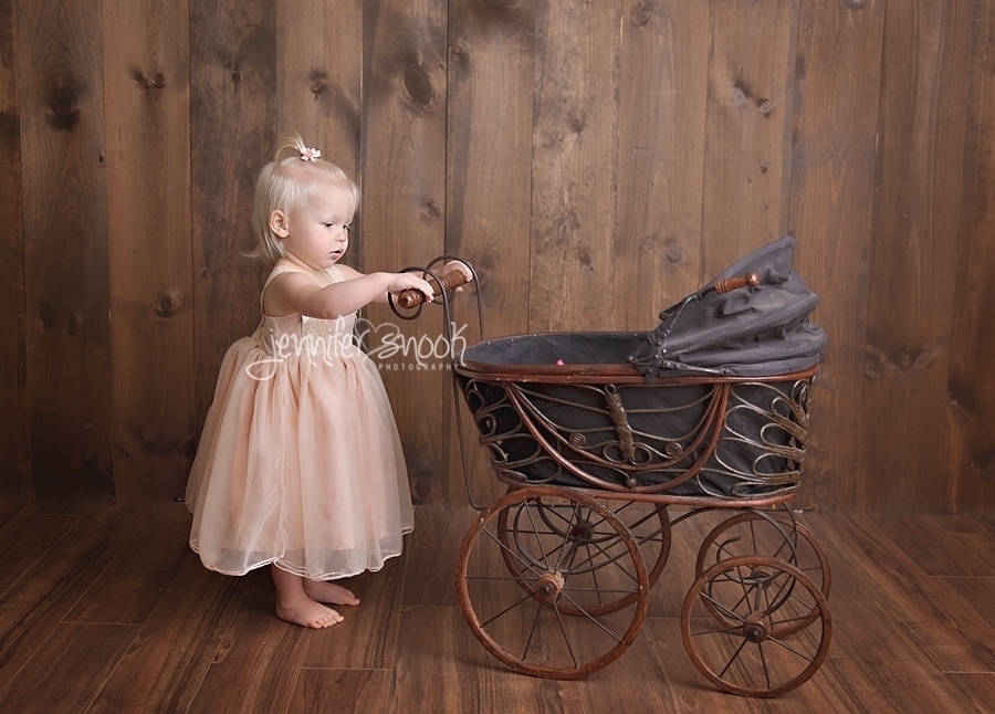 Baby girl with antique stroller